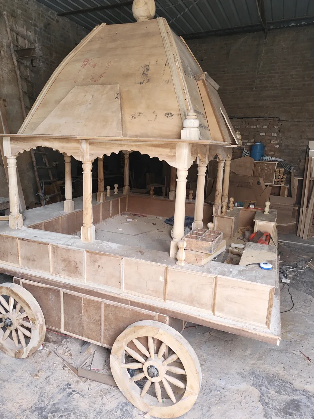AI-retouched workshop photograph of a wooden temple ratham under construction